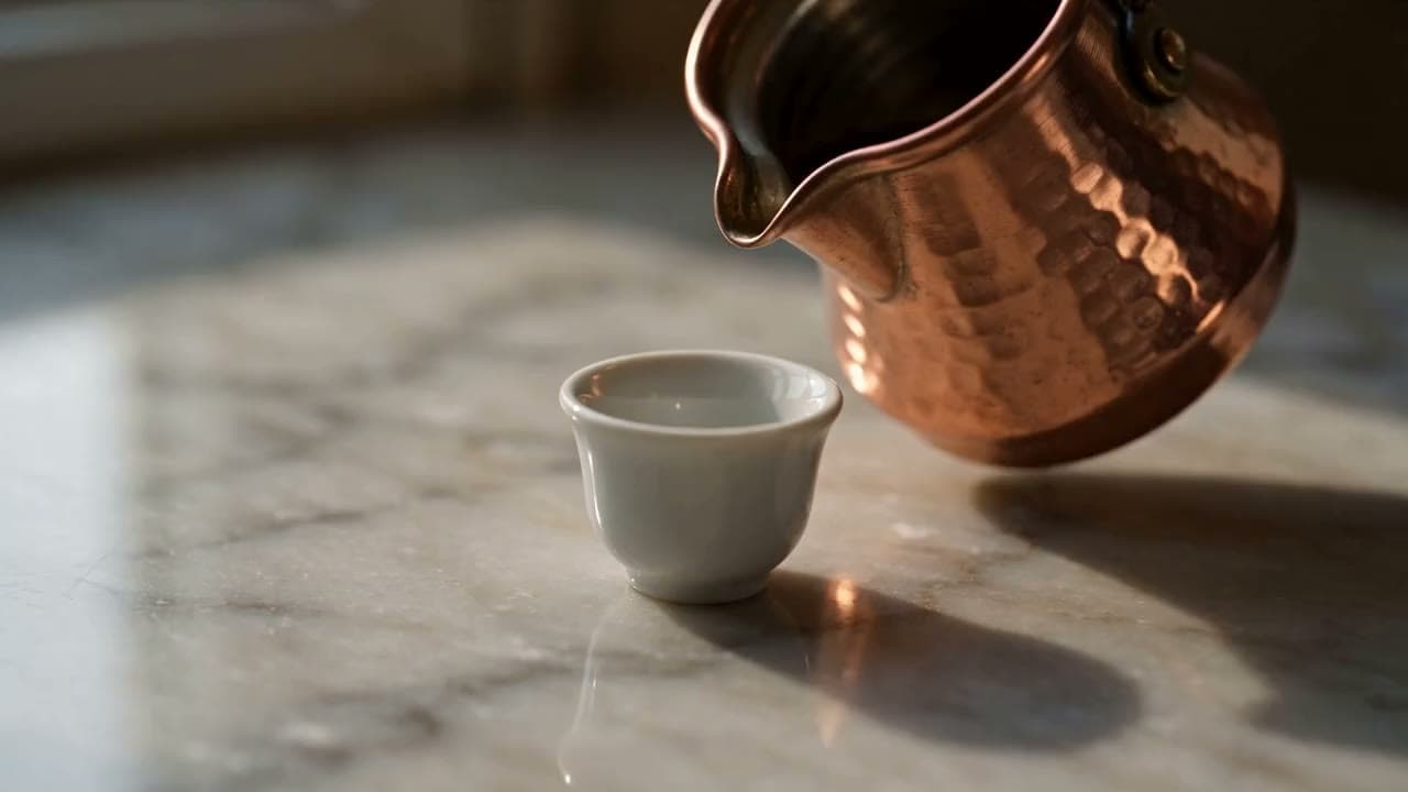 A miniature world: coffee poured from a tiny copper pot into a thimble-sized cup, tilt-shift macro. Still from a video made with Seedance 2.5.